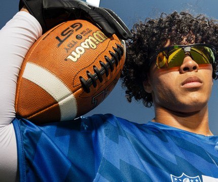 Flag football player with a football on his shoulder